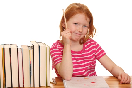 Portrait of a young girl doing her homework isolated on white backgroundの写真素材