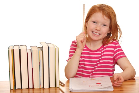 Portrait of a young girl doing her homework isolated on white backgroundの写真素材