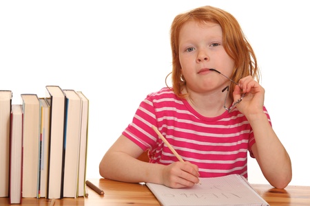 Portrait of a young girl doing her homework isolated on white backgroundの写真素材
