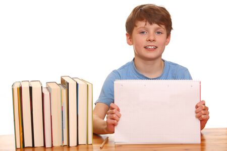 Portrait of a young boy doing his homework isolated on white backgroundの写真素材