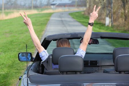 Young woman driving a sports cabriolet carの写真素材
