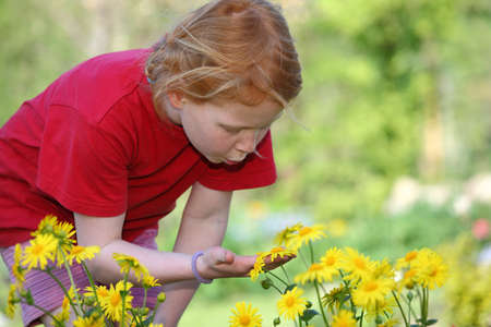 Young girl in the garden with flowersの写真素材