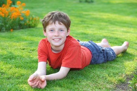 Portrait of a young boy lying in the grassの写真素材