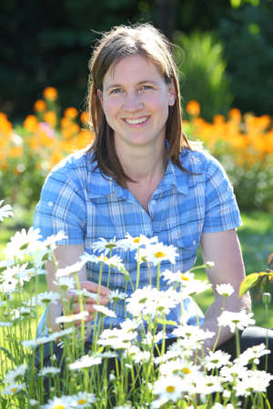 Happy young smiling woman with flowersの写真素材