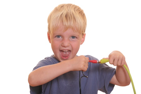 Young boy tries to connect two different cablesの写真素材