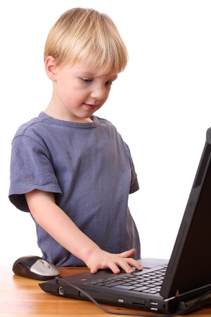 Portrait of a young boy working on a laptop computerの写真素材