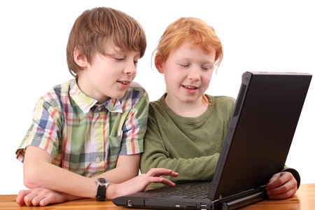 Boy and girl working together on a laptop computerの写真素材