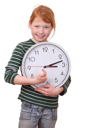 Portrait of a young girl holding a clock isolated on white backgroundの写真素材