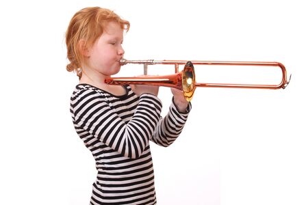 Young girl playing a trombone on white backgroundの写真素材