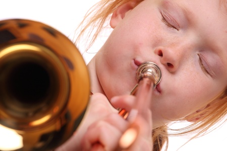Young girl playing a trombone on white background
