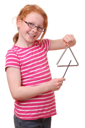 A young girl plays with a triangle の写真素材