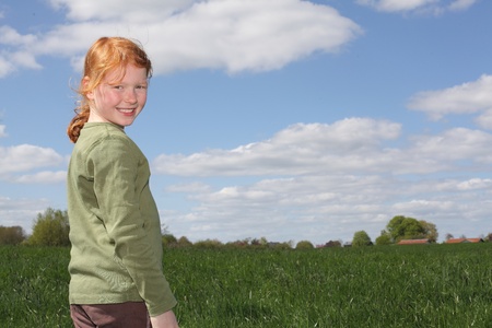 Portrait of a redhaired girl in a meadowの写真素材