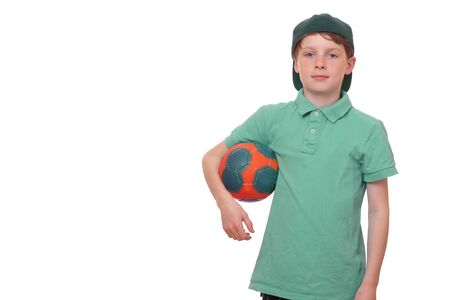 Happy young boy holds a ball on white backgroundの写真素材