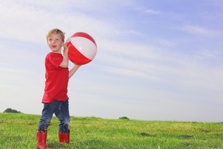 Young boy playing outdoors with a ballの写真素材