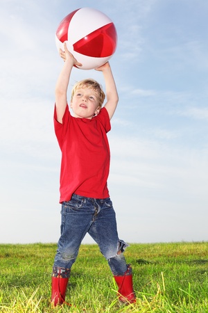 Young boy playing outdoors with a ballの写真素材