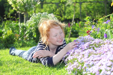 Young girl enjoys some flowers in the gardenの写真素材