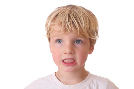 Portrait of an angry young boy on white backgroundの写真素材