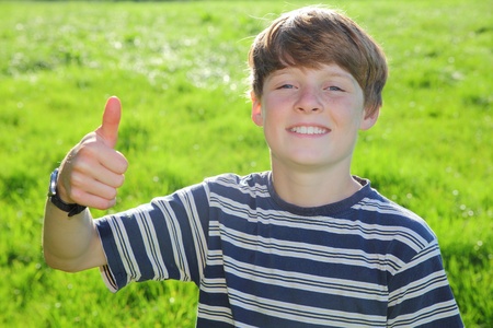 Happy young boy shows thumb upの写真素材