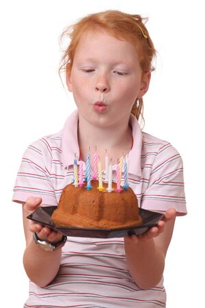 Young girl blowing candles on her birthday cake の写真素材
