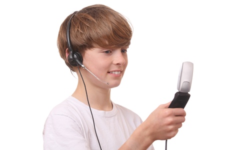 Young boy with cell phone and headset on white backgroundの写真素材