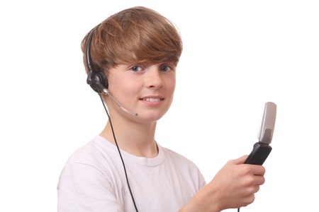 Young boy with cell phone and headset on white backgroundの写真素材