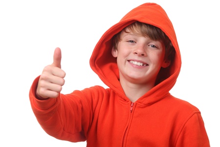 Young boy wearing a hoodie shows thumbs up on white backgroundの写真素材