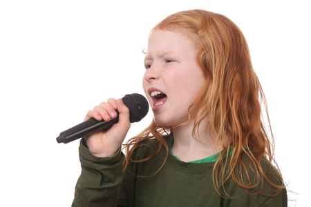 Young red haired girl singing into microphone on white backgroundの写真素材
