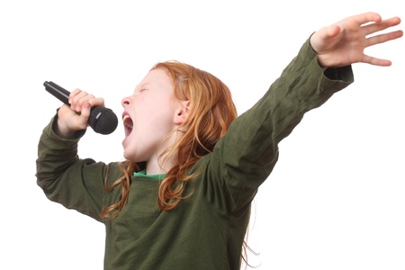 Young red haired girl singing into microphone on white backgroundの写真素材