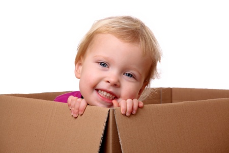 Portrait of a happy young toddler sitting in a boxの写真素材