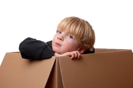 Portrait of a happy young toddler sitting in a boxの写真素材