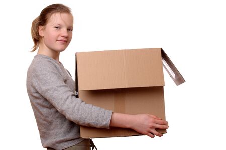Portrait of a happy young girl carrying a large boxの写真素材
