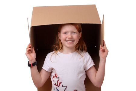 Portrait of a happy young girl carrying a large boxの写真素材