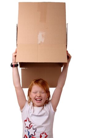 Portrait of a happy young girl carrying a large boxの写真素材