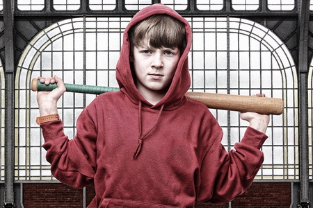 Cool young teenage boy with a baseball batの写真素材