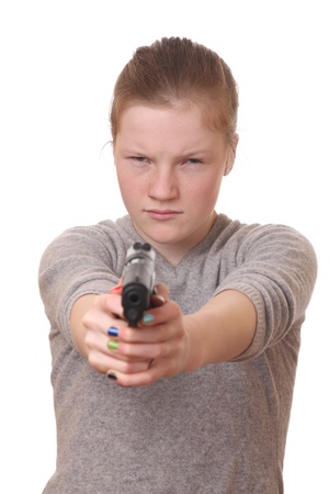 Portrait of a young teenage girl with a gun on white backgroundの写真素材