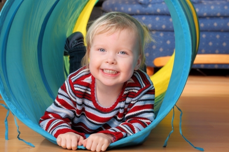 Happy toddler plays indoor in a tunnelの写真素材