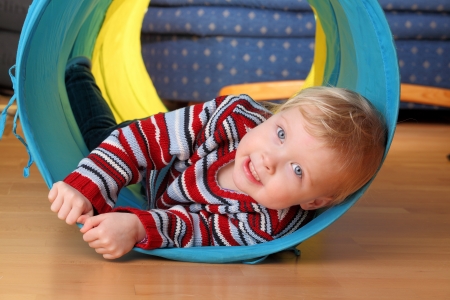 Happy toddler plays indoor in a tunnelの写真素材