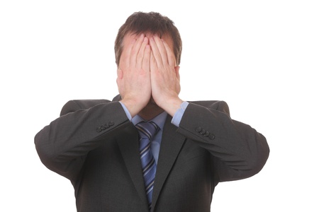 Stressed businessman covering his face with his hands on white backgroundの写真素材