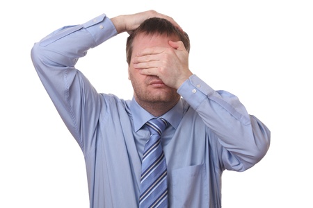 Stressed businessman covering his face with his hands on white backgroundの写真素材