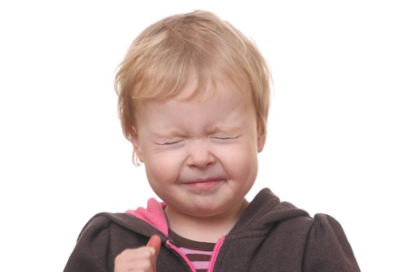 Portrait of a young toddler with eyes closed on white backgroundの写真素材