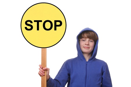 Portrait of a teenager holding a stop sign on white backgroundの写真素材