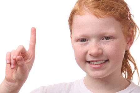 Portrait of a young girl with raised finger on white backgroundの写真素材