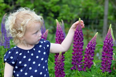 Happy girl in the garden with flowersの写真素材