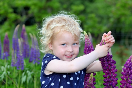 Happy girl in the garden with flowersの写真素材