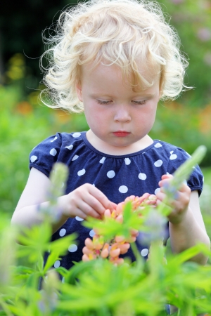 Happy girl in the garden with flowersの写真素材