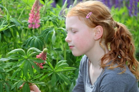 Happy girl in the garden with flowersの写真素材