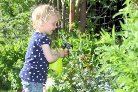Happy child in garden sprays rosesの写真素材