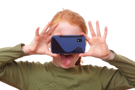 Red haired girl does funny things with her smartphoneの写真素材