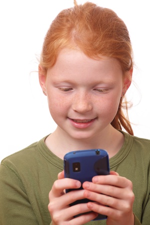 Red haired girl plays with her new smartphoneの写真素材