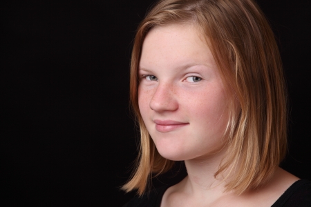 Portrait of a teenage girl on black backgroundの写真素材